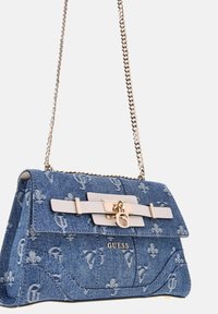 Borsa in denim con motivo floreale, tracolla in catena argentata e dettagli dorati. Presenta una chiusura frontale con logo e una forma strutturata.