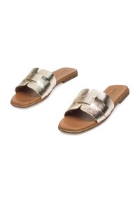 Sandalias planas deslide con un upper texturizado en dorado metálico, con dos correas anchas y una suela en tono marrón. Superficie suave con detalles mínimos.