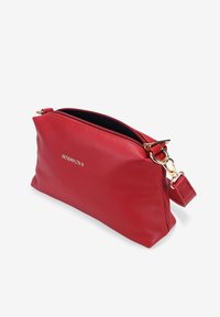 Pochette in pelle rossa con texture a ciottoli e hardware dorato, chiusura a zip e tracolla staccabile. Forma rettangolare compatta con finitura testurizzata.