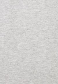 Ljust grått tyg med en mjuk textur, som har ett subtilt melerat mönster. Materialet ser ut att vara bomullsliknande och har en jämn finish.