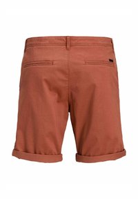 Short pour hommes de couleur rouille avec ourlets roulés, deux poches passepoilées à l’arrière et passants de ceinture, vus de dos sur fond blanc.