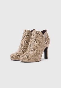 Bottes à talons hauts beiges avec un motif en peau de serpent, bout rond et texture lisse. Présente un haut incurvé et un talon aigu étroit.