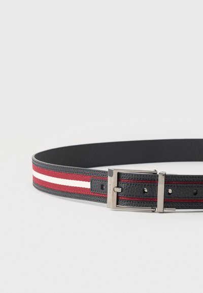 Μαύρη δερμάτινη ζώνη με ενσωματωμένο ύφασμα με κόκκινες και λευκές ρίγες και ασημένια ορθογώνια μεταλλική αγκράφα, τοποθετημένη επίπεδη σε λευκή επιφάνεια.