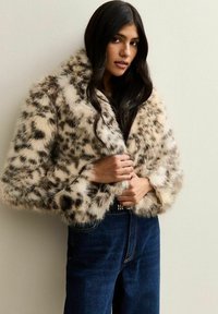 Jasje van nepbont met luipaardprint, met een brede kraag, cropped ontwerp en een zachte textuur, gecombineerd met donkerdenim jeans met hoge taille.