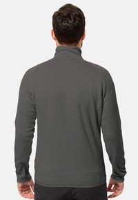 Veste en polaire grise avec un col montant, des manches longues et une texture lisse. Présente une silhouette ajustée et aucun élément de design visible.