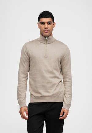 Beżowa bluza z pół zapięciem, wykonana z miękkiej dzianiny, z prążkowanym kołnierzem i mankietami. Dopasowany krój z delikatną teksturą i czystymi liniami.