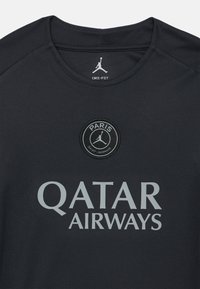 Czarny koszulka Dri-FIT z szarymi logo: okrągła odznaka Paris Saint-Germain i napis "QATAR AIRWAYS". Gładka tkanina, fason z okrągłym dekoltem.