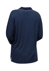 Camisa de manga larga azul marino con cuello y ribete blanco. Tejido suave, corte holgado, aberturas laterales para mayor libertad de movimiento. Sin patrones ni detalles visibles.