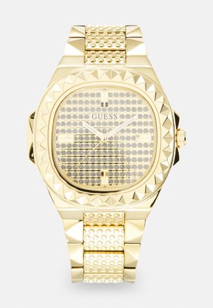 Goldfarbene Uhr mit quadratischem Ziffernblatt, strukturiertem Gehäuse und mit Steinen besetztem Armband. Das Ziffernblatt zeigt ein Gitter aus schimmernden Akzenten.