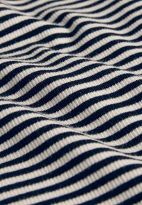 Tela de algodón con franjas horizontales alternas en azul marino y blanco, con una superficie texturizada ligeramente elevada que crea un efecto ondulado.