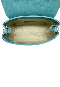 Tyrkysová kožená kabelka s měkkou texturou, s krémovou podšívkou a jednoduchým otevřeným designem pro snadný přístup.