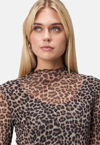 Gennemsigtig langærmet top med leopardprint i nuancer af beige og sort, med en bølget halsudskæring og en tætsiddende silhuet.
