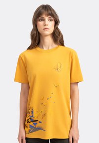 Geel katoenen T-shirt met korte mouwen, ronde halslijn, voorzien van een blauw abstract grafisch ontwerp en een klein handafdrukembleem op de borst.
