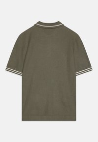 Tamsiai žalia polo marškinėlių su tekstūruotu audiniu, baltos juostelės apykaklė ir rankovių akcentai. Trumpomis rankovėmis ir tiesiu apvadu.