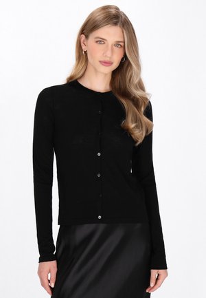 Musta pitkähiha cardigan pehmeästä kankaasta, jossa on pyöreä pääntie ja edessä kiinnitys kiiltävillä nappi.