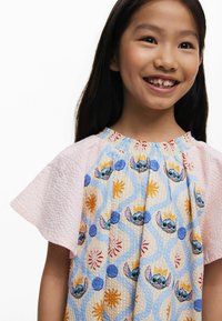 Baumwollkleid mit kurzen rosa strukturierten Ärmeln und einem gemusterten blauen Körper mit Illustrationen einer Figur, Kreisen und floralen Designs.