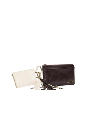 Deux petits portefeuilles en cuir, l'un blanc et l'autre brun foncé avec des glands et des porte-clés métalliques attachés, présentés sur un fond blanc.