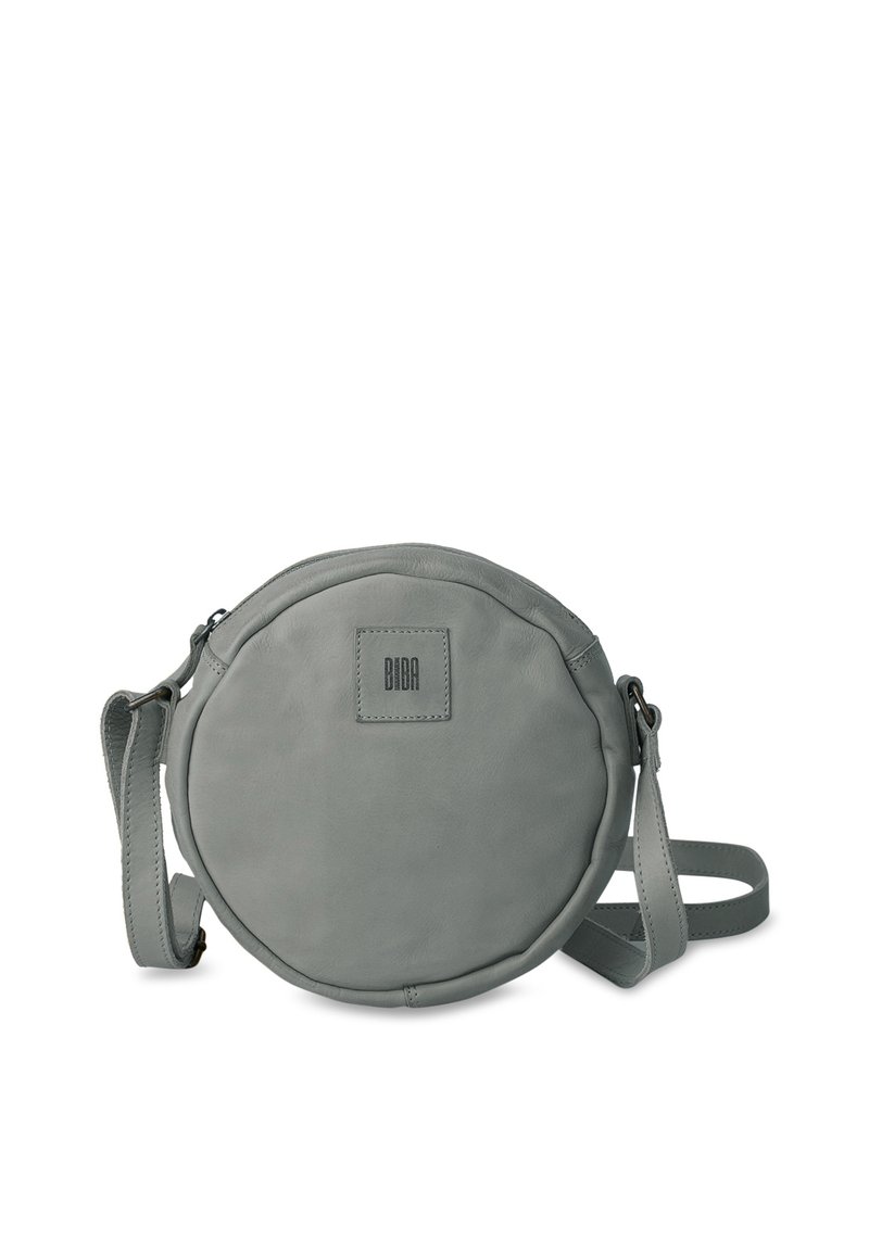 Rund, grå lädercrossbodyväska med platt topp, justerbar rem och fyrkantig logotypapplikation; har en slät yta och dragkedjestängning.