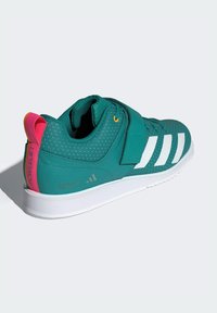 Tyrkysová športová obuv s bielymi pruhmi, polstrovaným golierom a ružovým pútkom na päte. Vyznačuje sa perforovanou textúrou a plochou bielou podrážkou s brandingom.