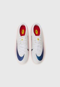 White athletic shoes with navy blue accents and a textured design. Features red insoles and white laces. The outsole is slightly translucent.