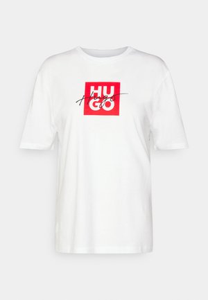 Valge puuvillane T-särk, mille ees on punane ruudukujuline graafika, kus on kirjas "HUGO" ning käekiri "Hugs". Lühikesed varrukad ja ümar kaelus.