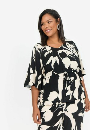 Haut à motif floral noir et blanc avec des manches courtes, une taille nouée et une coupe décontractée. Fabriqué en tissu léger avec une texture lisse.