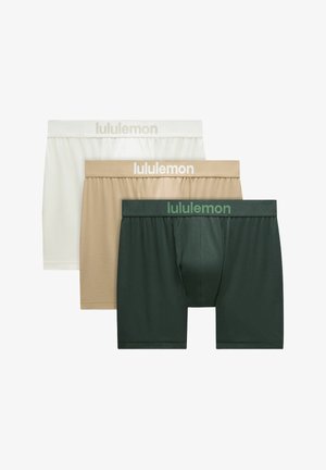 Tres pares de calzoncillos tipo bóxer para hombre en blanco, beige y verde oscuro, cada uno con una cintura elástica de la marca "lululemon."