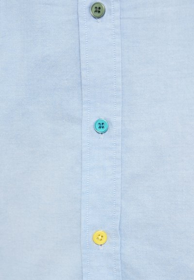 Cămașă albastru deschis cu șase nasturi în verde, turcoaz și galben. Materialul are o țesătură texturată, iar nasturii au un design clasic cu patru găuri.
