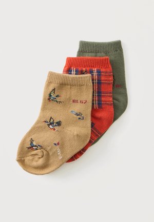 Drei Paare gefaltete Babysocken in Beige mit Vogelmustern, Rot mit blauem Karomuster und einfarbig Grün auf weißem Hintergrund.