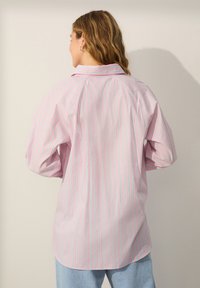 Langærmet skjorte med krave, med lyserøde og lyseblå lodrette striber, lavet af et blødt stof, med en rundet kant.