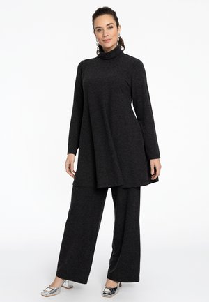Donkergrijze, lange mouw tuniek met een hoge kraag en asymmetrische zoom, gecombineerd met bijpassende wijde broek. Soepele stoftextuur, minimale details.