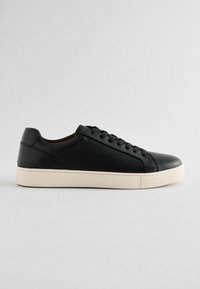 Sneakers negre din piele cu o finisare texturată, având o talpă din cauciuc crem, șase orificii pentru șireturi și un design elegant.