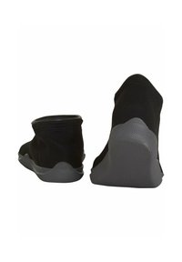 Scarpe in tessuto nero con caviglia elastica, punta tonda e suole in gomma grigia. Il design presenta una texture liscia e dettagli minimi.