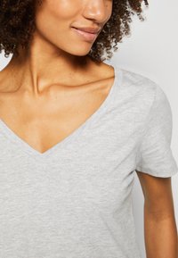 Gray, short-sleeve V-neck t-shirt made of soft fabric. Features a relaxed fit with subtle texture and a classic neckline.