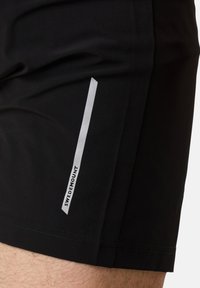 Svarta träningsshorts med en slät textur, featuring en vit vertikal rand och texten "SWEDEMOUNT" längs sidan.