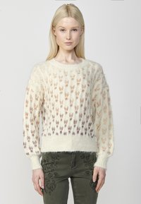 Pulover tricotat în crem cu un model texturat de motive suprapuse în roz pal și mov. Manșete și tiv cu elastic, textură pufoasă.