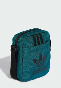 Borsa esagonale color teal con logo Adidas nero. Presenta accenti a strisce nere e una tracolla regolabile per maggiore versatilità.