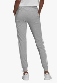 adidas Sportswear Spodnji deli trenirk - medium grey heather/white