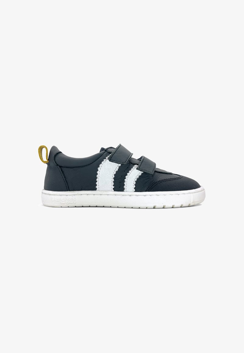 Basket noire pour enfant avec deux bandes velcro, semelle blanche, bandes latérales blanches et boucle jaune au talon sur fond blanc uni.