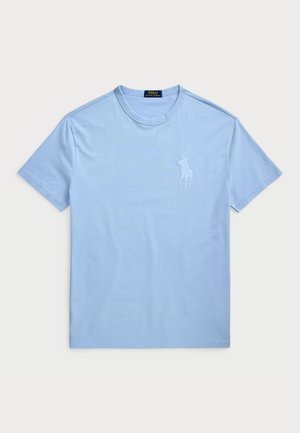 Světle modré bavlněné tričko s krátkým rukávem a kulatým výstřihem. Obsahuje vyšívané logo na levé části hrudníku. Hladká textura.