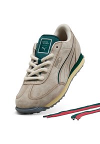 Sneaker beige in camoscio con accenti verdi, dotato di punta rotonda, lacci testurizzati e suola intermedia gialla. Include lacci aggiuntivi in verde e rosso.