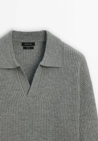 Pull en laine gris côtelé avec col ouvert et profond décolleté en V, étiquette Massimo Dutti, étalé à plat sur un fond blanc.