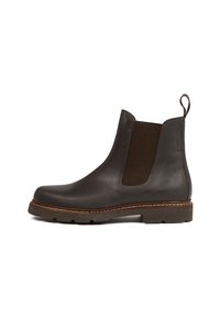 Bottines en cuir marron avec panneaux élastiques sur les côtés, bout arrondi et semelle en caoutchouc texturé. Caractérisées par un liseré cousu et une anse au talon.