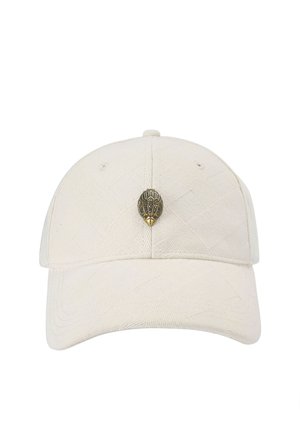 Witte honkbalpet met subtiel gestructureerd patroon en een klein metalen embleem in de vorm van een gestileerd vogelhoofd, gecentreerd op het voorpaneel.