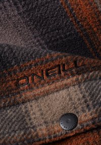 Herre skovmandsskjorte i ruder i mørkegrå, orange og beige nuancer. Udstyret med broderet logo og sort knapdetalje. Blødt stof.
