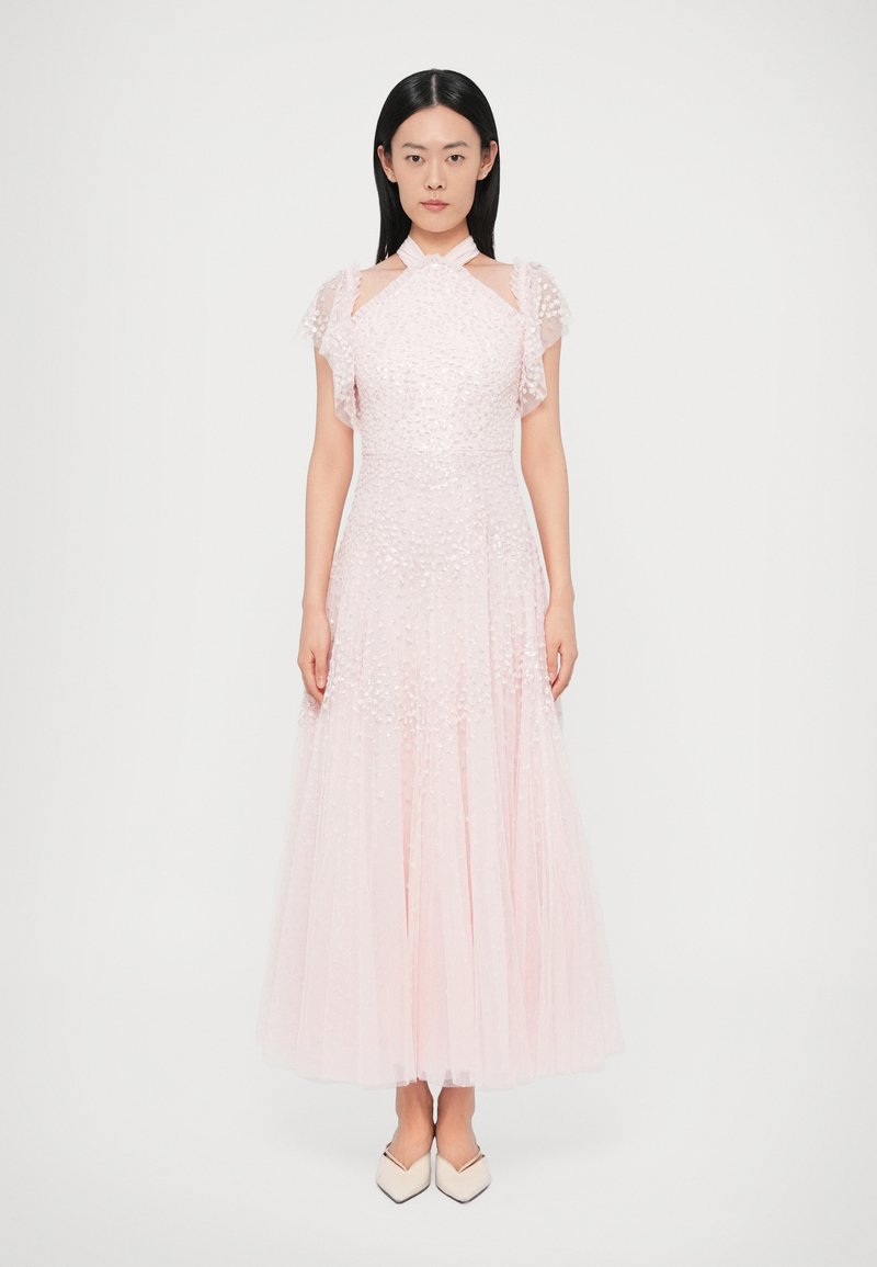 Hosszú pasztell rózsaszín ruha texturált anyagból, rövid fodros ujjakkal és testhezálló felsőrésszel. A deréktól bő szoknya hullámzik.