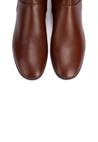 Braune Lederstiefel bis Knöchel mit einer glatten Oberfläche, runder Zehenform, minimaler Nahtführung und einer schwarzen Gummisohle.