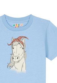 T-shirt bleu clair avec une illustration de cheval blanc portant un bandana à pois rouges. Tissu doux avec un col rond et des manches courtes.