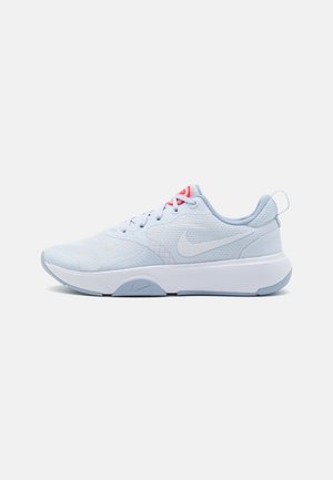 Lyseblå Nike løbesko med hvid sål, åndbart mesh-overdel, snørelukning og rød detalje tæt på tungen mod en ensfarvet baggrund.