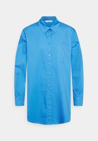 Camisa azul de mangas longas, com botões, feita de tecido suave, apresentando um colarinho clássico e um bolso no peito. Design simples, sem padrões.